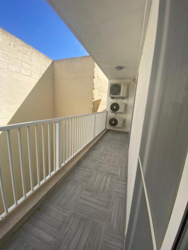 a hallway with a white railing and a stairway at Marsalforn luxurious Apartment in Marsalforn