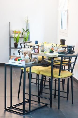 a dining room table with yellow chairs and food on it at Corte Giorgi in Breno