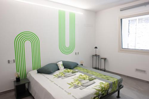 a bedroom with a large bed with green and white sheets at Corte Giorgi in Breno