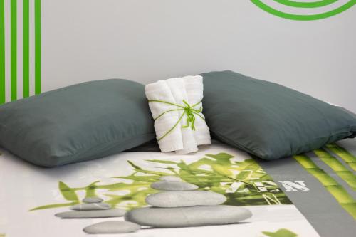 a bed with two pillows and rocks on it at Corte Giorgi in Breno