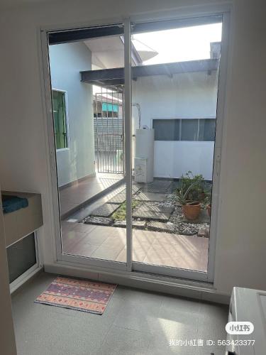 a sliding glass door in a room with a patio at Pelita Commercial Centre Homestay 百丽达商圈民宿 9pax in Miri