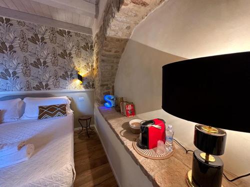 een slaapkamer met een bed en een flatscreen-tv bij La Bartolomea Home & Suite in Pitigliano