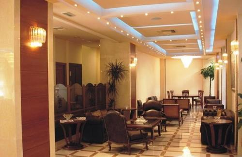 a lobby with chairs and tables in a restaurant at Elena Hotel in Kozani