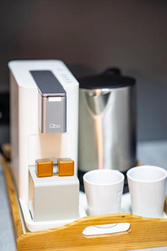 a coffee maker sitting next to cups on a counter at Hotel CityHome am Kurpark in Bad Salzuflen