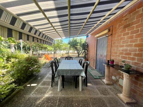 eine Terrasse mit einem Tisch, Stühlen und einer Ziegelwand in der Unterkunft Uacella in Locorotondo