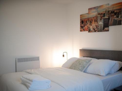 a white bed with towels on it in a bedroom at Stunning 2bedroom Apartment in Manchester