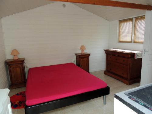 une chambre avec un lit rouge et deux tables de nuit dans l'établissement Mobil home & studio 6 pers Parc de loisirs, à Talmont-Saint-Hilaire