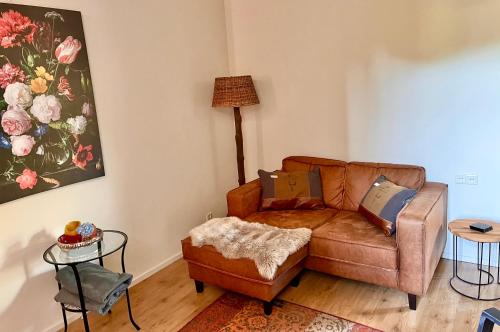uma sala de estar com um sofá e uma mesa em Bed and Breakfast De Paalberg em Hoenderloo