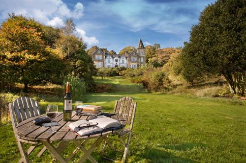 a picnic table with a bottle of wine and two chairs at Yewfield Vegetarian Guest house in Ambleside