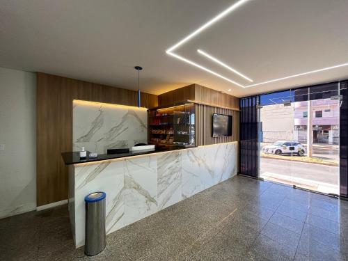 a lobby with a counter with marble counter top at Hotel Suntuoso in Brasilia