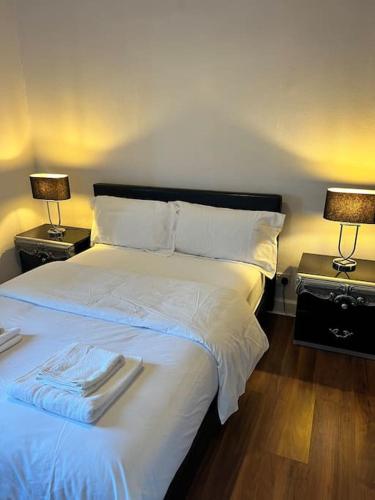a bedroom with a large white bed with two lamps at Royal Apartments Edinburgh in Edinburgh