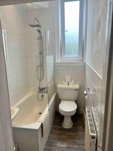 a bathroom with a toilet and a tub and a sink at Royal Apartments Edinburgh in Edinburgh