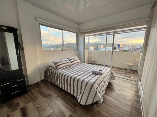 Schlafzimmer mit einem Bett und großen Fenstern in der Unterkunft El Mirador in Barbosa