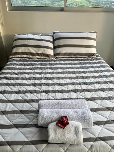 uma cama com duas toalhas e duas almofadas em El Mirador em Barbosa