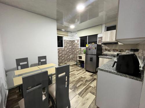 een keuken met een tafel en stoelen en een koelkast bij El Mirador in Barbosa