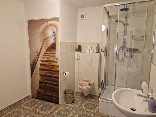 een badkamer met een douche, een wastafel en een toilet bij Mertens Zimmervermietung in Hamburg