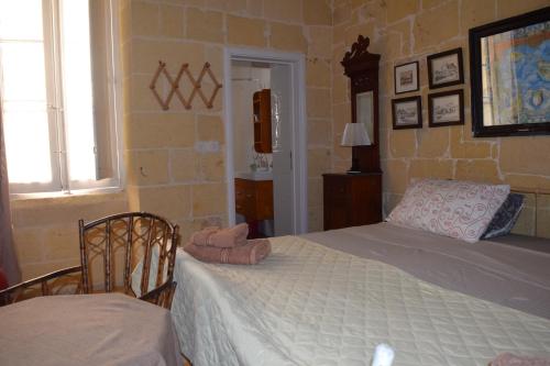 a bedroom with a bed and a chair in a room at Maria Townhouse Heart of Victoria B&B in Victoria