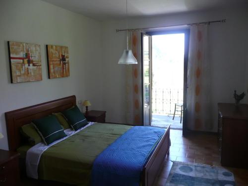 a bedroom with a bed and a sliding glass door at Vila with private pool in Licciana Nardi