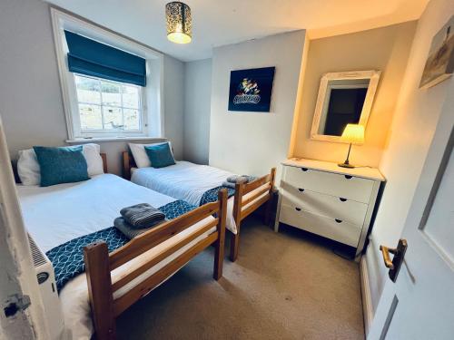 een kleine slaapkamer met 2 bedden en een spiegel bij 2 Bedroom Apartment ST9A, Ryde, Isle of Wight in Ryde