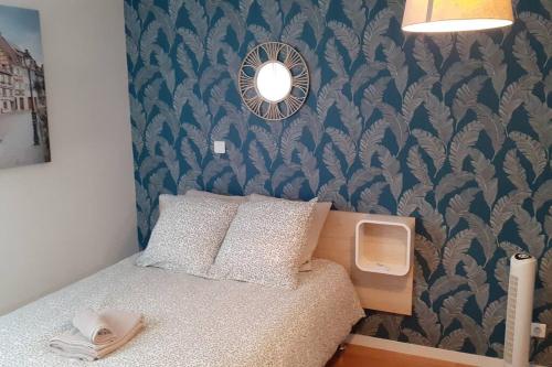 - une petite chambre avec un lit et un mur dans l'établissement Studio meublé Mulhouse, à Mulhouse