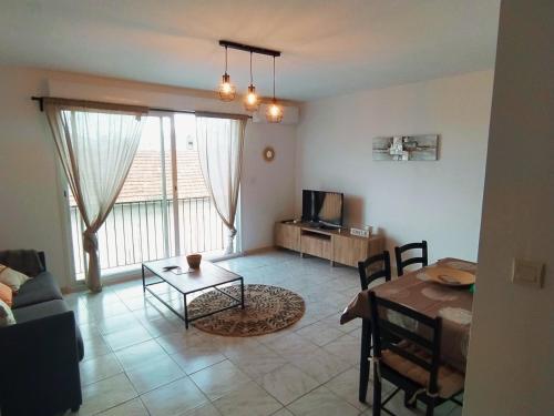 a living room with a table and a dining room at Appartement centre ville à deux pas de la plage in Le Grau-du-Roi