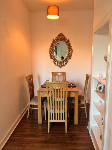 a dining room table with two chairs and a mirror at Royal Apartments Edinburgh in Edinburgh