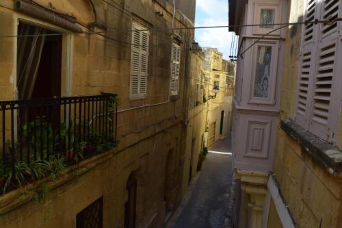 an alley in an old building with a balcony at Maria Townhouse Heart of Victoria B&B in Victoria
