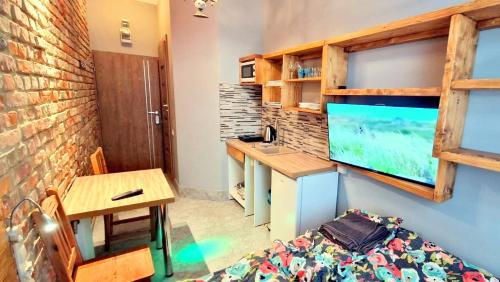 a small room with a desk and a table with a bed at Studio Centrum Wejście na kod Code entry in Szczecin