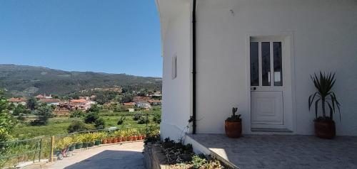 a white house with a door and a view of a valley at Grandma´s House in Lombinha