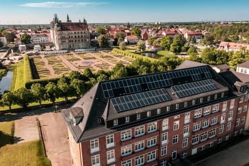 an aerial view of a building with solar panels on the roof at Hotel am Schlosspark in Güstrow