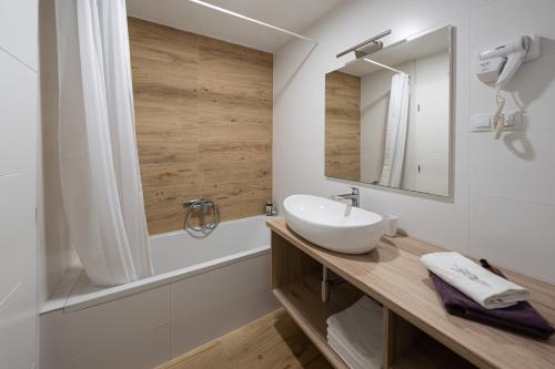 La salle de bains est pourvue d'un lavabo, d'un miroir et d'une baignoire. dans l'établissement Sea Melody, à Lopar