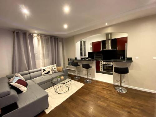 a living room with a couch and a kitchen at Bel appartement proche de Paris in Colombes