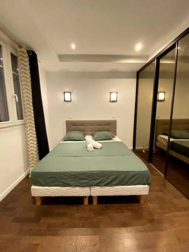 - une chambre avec un lit et une serviette blanche dans l'établissement Bel appartement proche de Paris, à Colombes