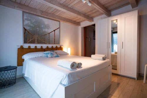 シラクーサにあるGeko's Houseのベッドルーム1室(壁に橋の絵画が描かれた白いベッド1台付)
