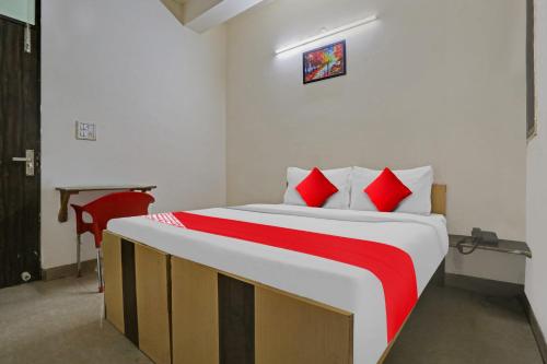 a bedroom with a large bed with red pillows at OYO Flagship Hotel Stanley Falls in Gurgaon