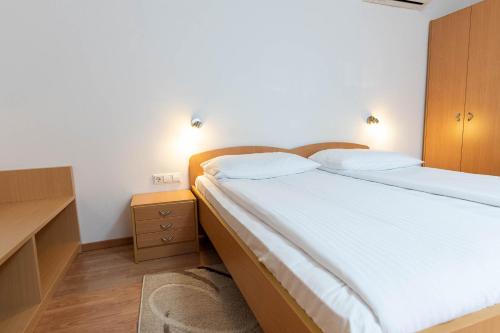 a bedroom with a large bed and a wooden cabinet at Apartmaji in sobe RaMar in Straža