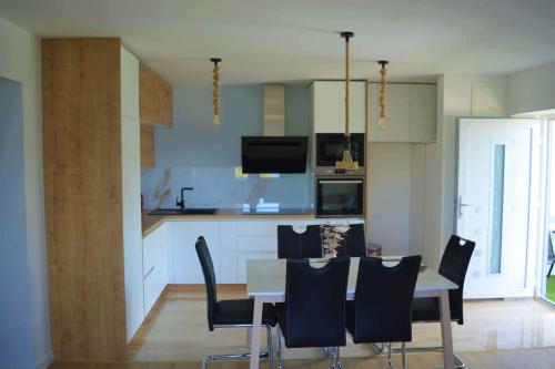 een eetkamer en een keuken met een tafel en stoelen bij Apartment Kuman in Omiš