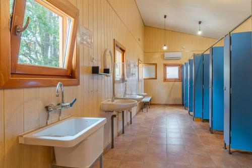 a bathroom with three sinks and a window at Camping Susen in Saldés