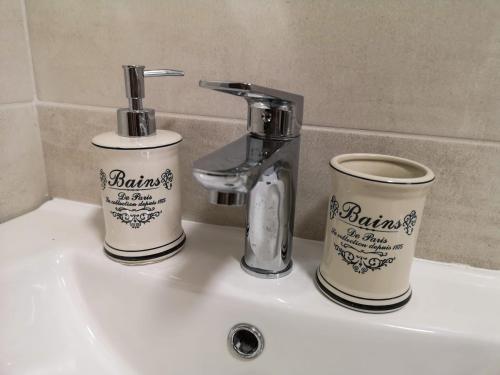 un lavandino in bagno con due tazze e un rubinetto di Casa Galina a Bucarest