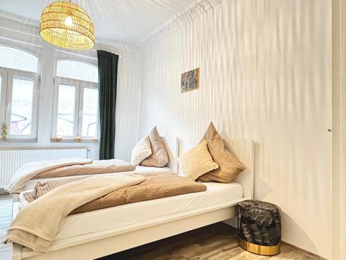 two beds in a white bedroom with a chandelier at Wellness Apartment - Sauna - 3 Schlafzimmer - 6 Personen - Zentrum in Hannover
