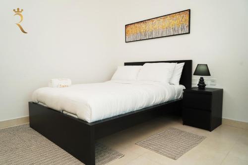 um quarto com uma cama preta e uma fotografia na parede em An Exclusive 2BR Retreat Experience Yas Island Bliss em Abu Dhabi