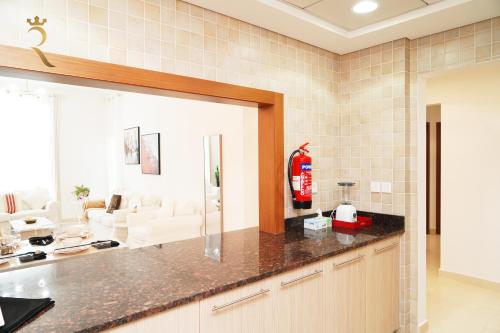 a kitchen with a counter top and a living room at An Exclusive 2BR Retreat Experience Yas Island Bliss in Abu Dhabi