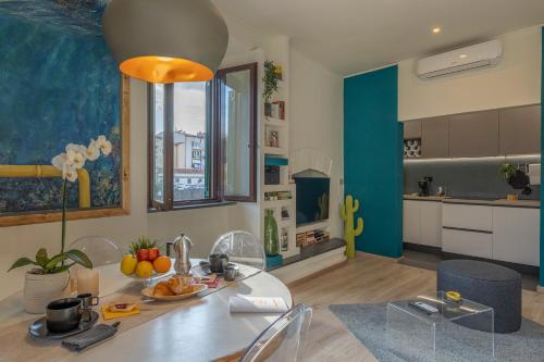 uma cozinha e sala de estar com mesa e cadeiras em The Architect Suite - Canals View em Livorno