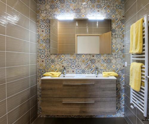 uma casa de banho com um lavatório e um espelho em L'Escale Donatienne em Nantes