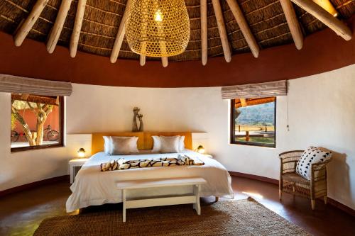 a bedroom with a bed and a chandelier at Zebras Crossing in Modimolle