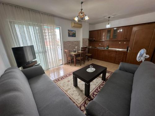 een woonkamer met een bank en een tafel bij Cozy apartment in the City Center in Shkodër