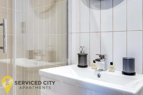 een witte badkamer met een wastafel en een douche bij SCA - Outstanding Studio - CR8 in Birmingham