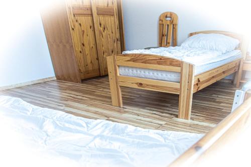 a bedroom with a bed and a wooden floor at Staberhuk links - XL Ferienwohnung - Sonnendurchflutet - Terrasse in Staberdorf