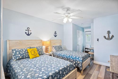 a bedroom with two beds and a ceiling fan at Upham Beach Inn - #3 Studio in St. Pete Beach