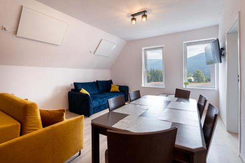 a dining room with a table and a couch at Mega widok 4 in Szklarska Poręba
